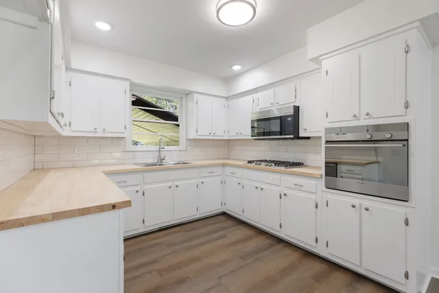 a view of empty room with wooden floor and fireplace