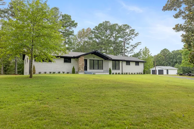 a view of a house with backyard and trees