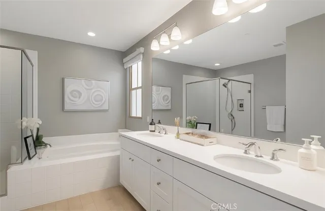 a bathroom with a double vanity sink tub double and mirror