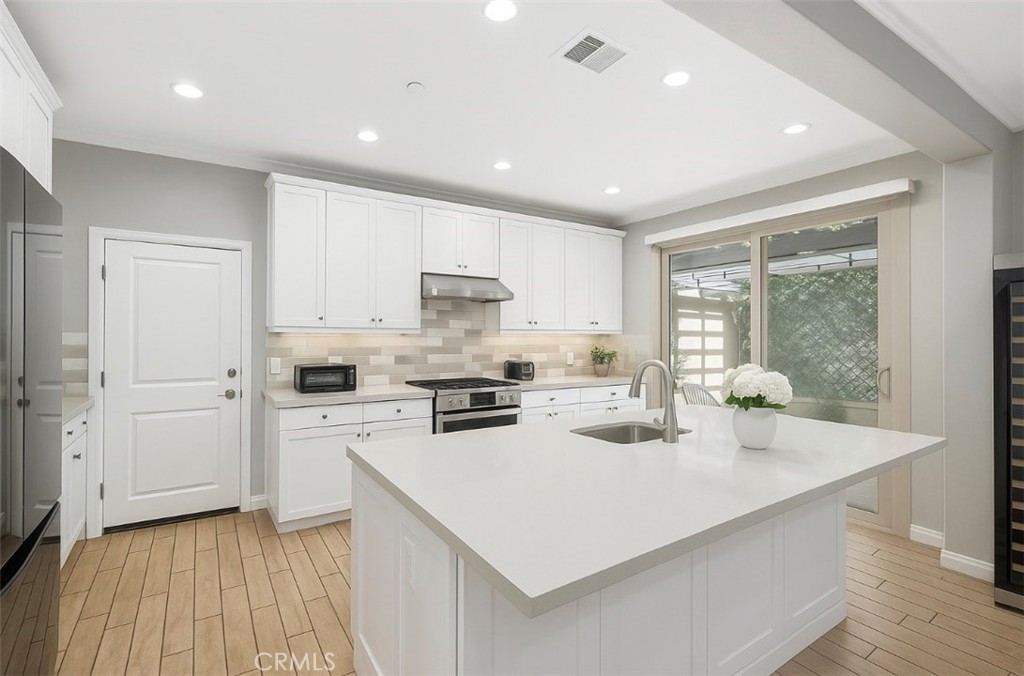 254 Kempton Irvine, CA 92620 - Photo 10 of 18 a kitchen with a sink a stove a refrigerator and white cabinets
