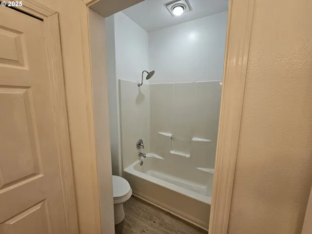 a bathroom with a granite countertop bathtub shower and toilet