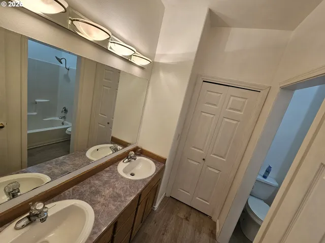 a bathroom with a granite countertop sink a mirror and a shower