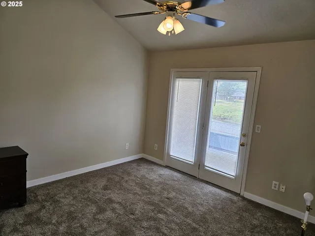 an empty room with windows and fan