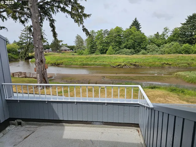 a view of a balcony with wooden floor and fence