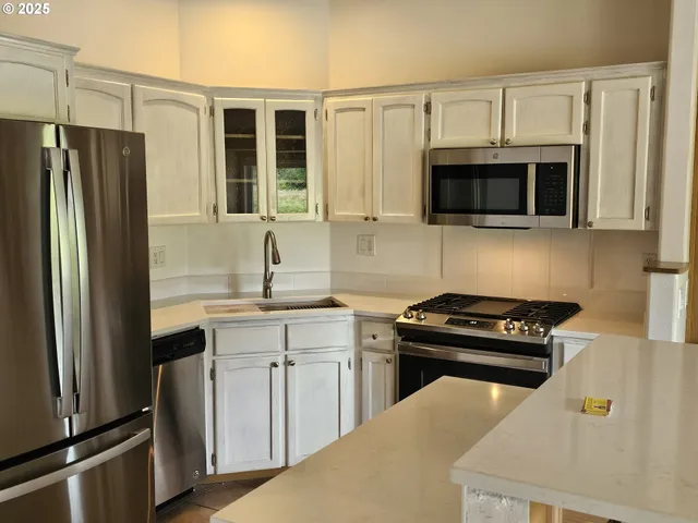 a kitchen with granite countertop a refrigerator stove and microwave