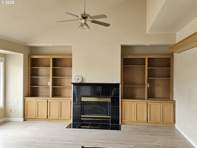 a living room with a fireplace and a ceiling fan