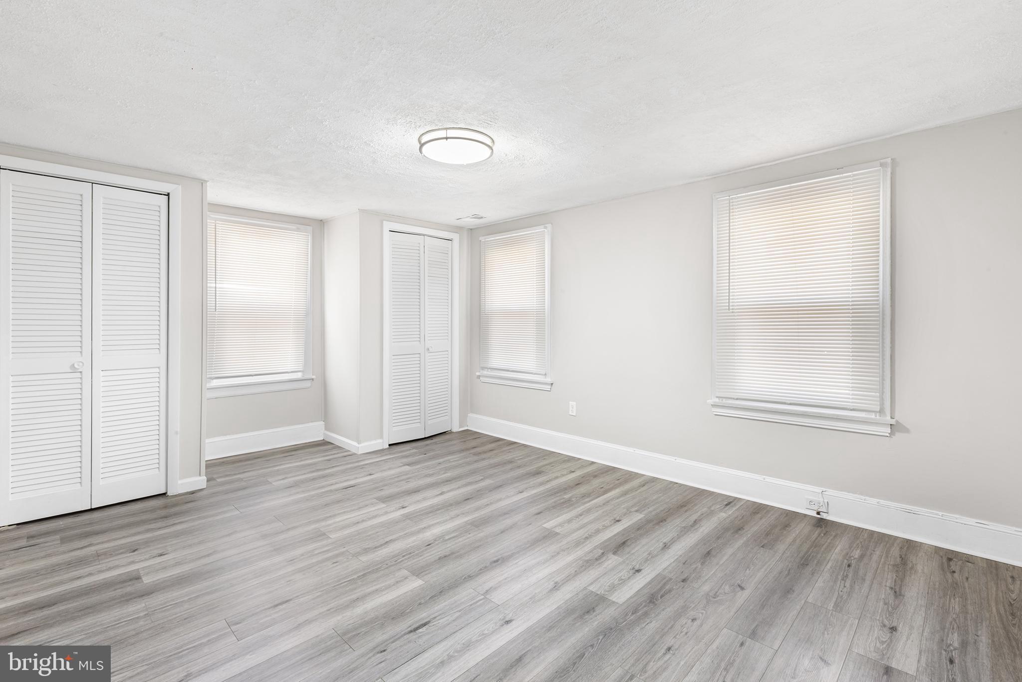205 Callanan Avenue Bryn Mawr, PA 19010 - Photo 15 of 26 an empty room with wooden floor and windows