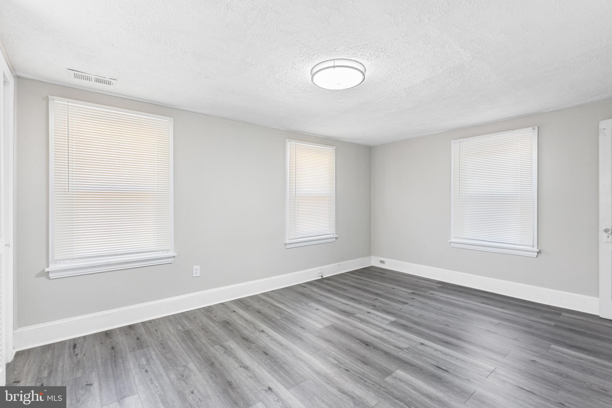 205 Callanan Avenue Bryn Mawr, PA 19010 - Photo 16 of 26 an empty room with wooden floor and windows