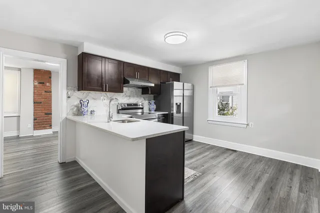 a kitchen with granite countertop a refrigerator and a stove top oven