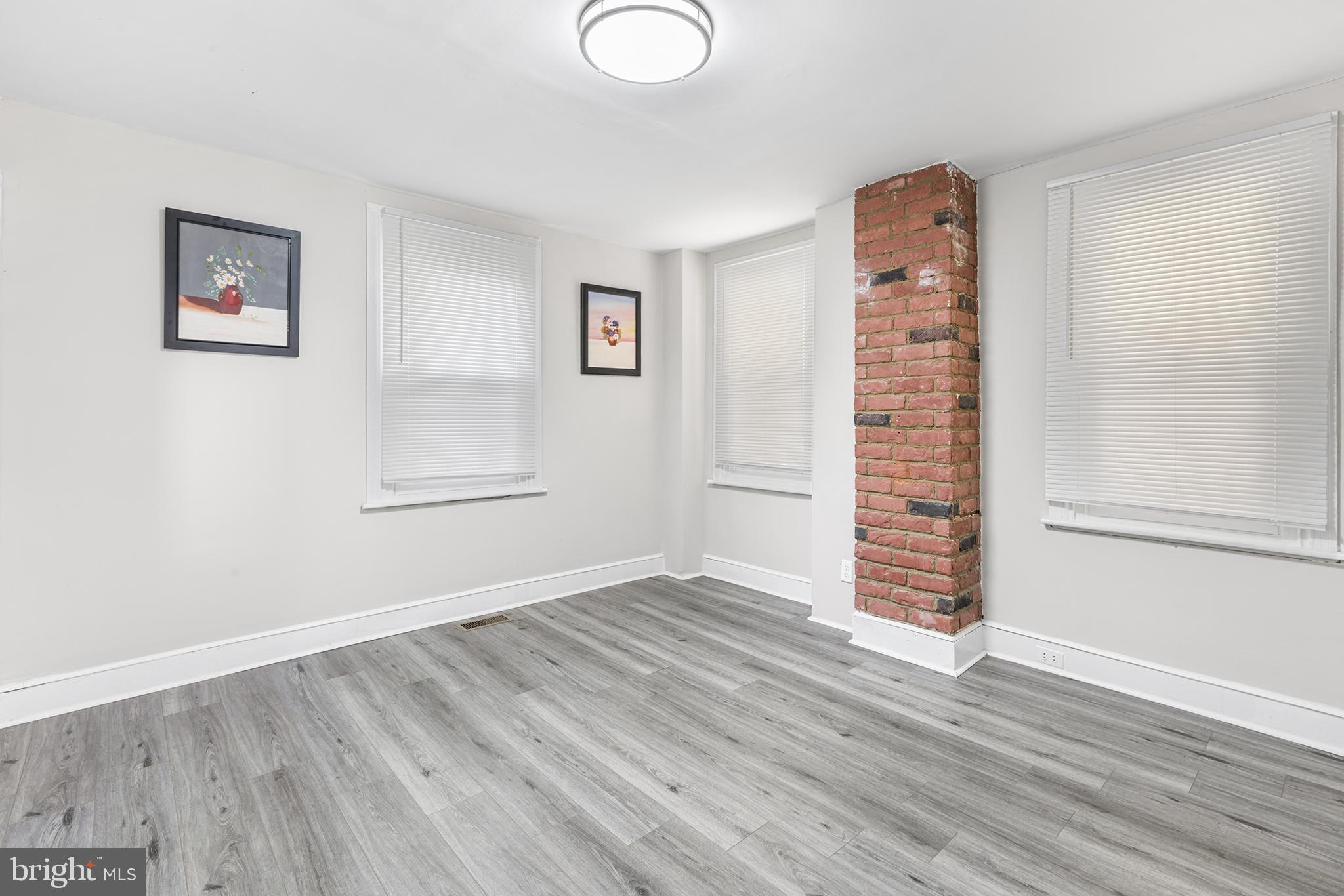 205 Callanan Avenue Bryn Mawr, PA 19010 - Photo 7 of 26 an empty room with wooden floor and windows