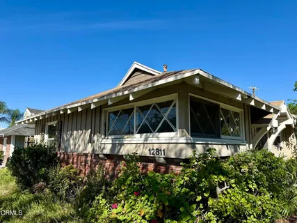 a front view of a house with plants