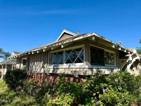 a front view of a house with plants