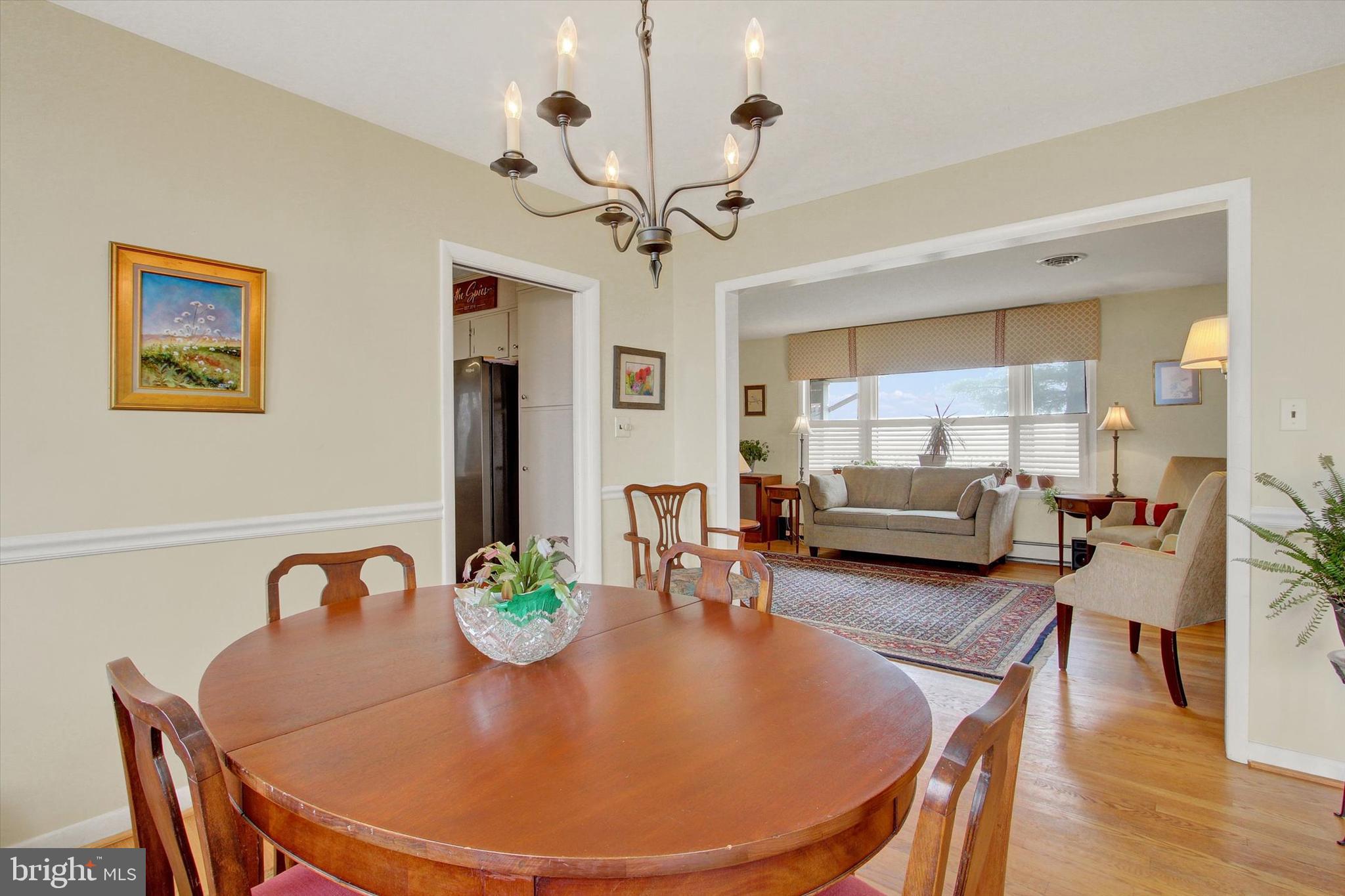 110 Lees Mill Road Hampstead, MD 21074 - Photo 12 of 39 a view of a dining room with furniture a chandelier and wooden floor