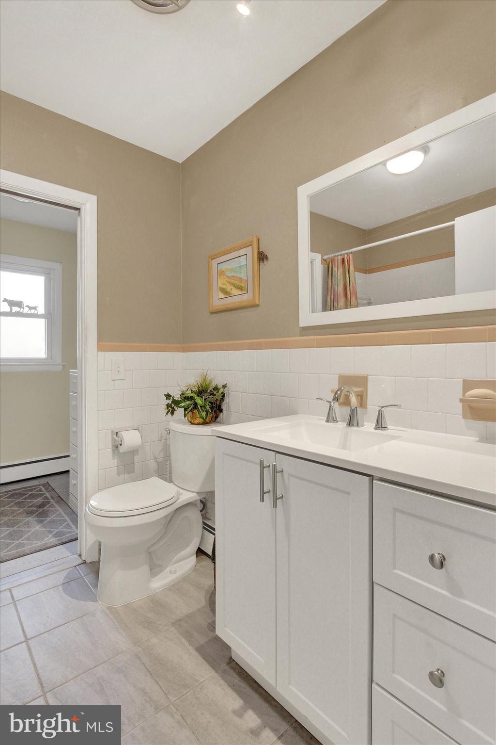 110 Lees Mill Road Hampstead, MD 21074 - Photo 25 of 39 a bathroom with a toilet a sink a mirror and vanity