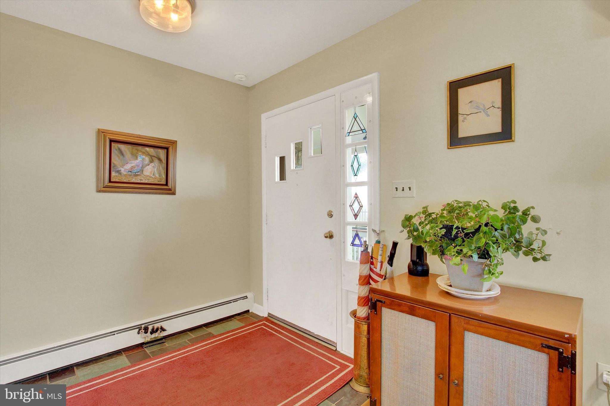 110 Lees Mill Road Hampstead, MD 21074 - Photo 4 of 39 a room with painting on the wall and a potted plant