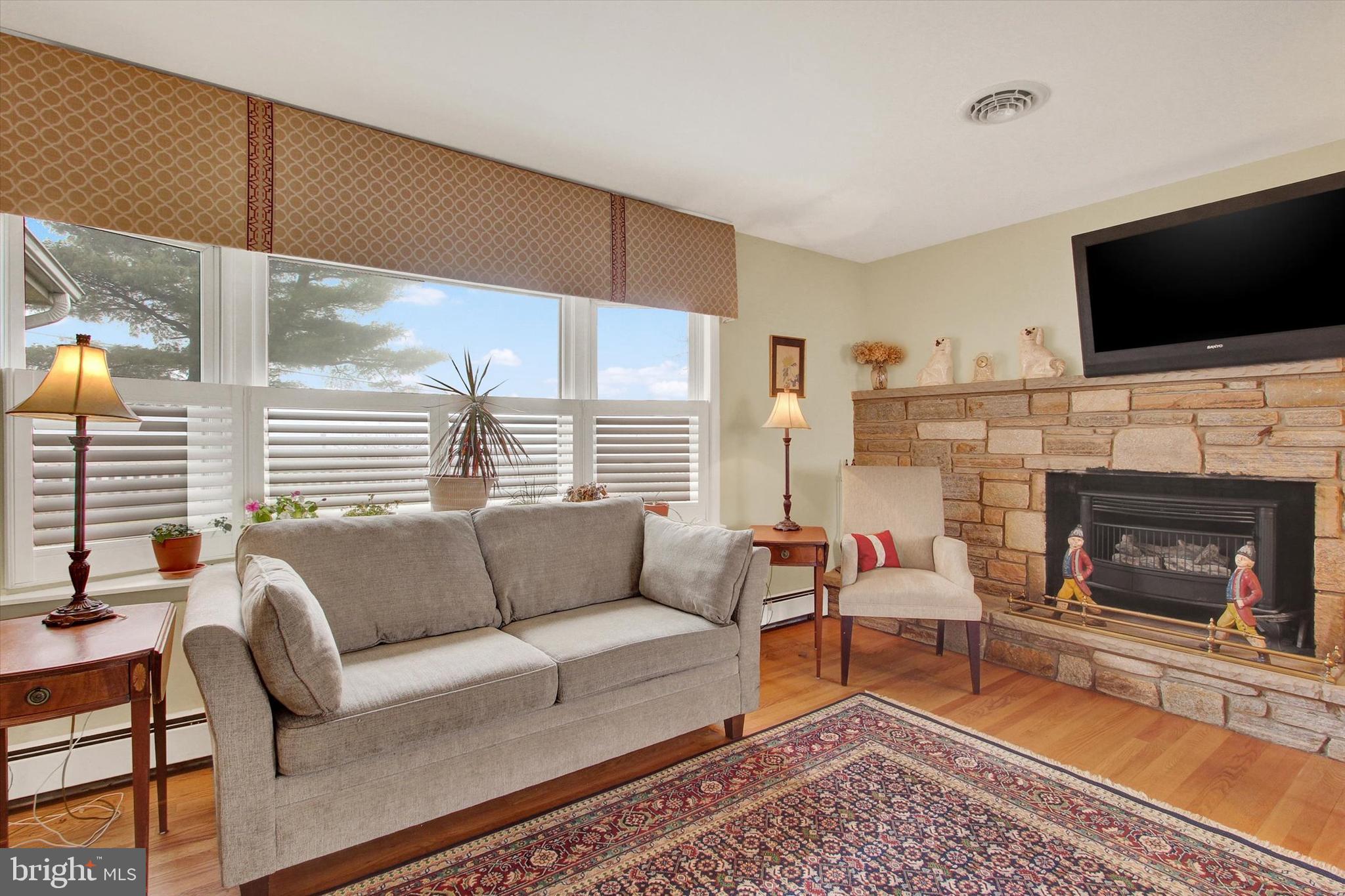 110 Lees Mill Road Hampstead, MD 21074 - Photo 7 of 39 a living room with furniture a flat screen tv and a fireplace