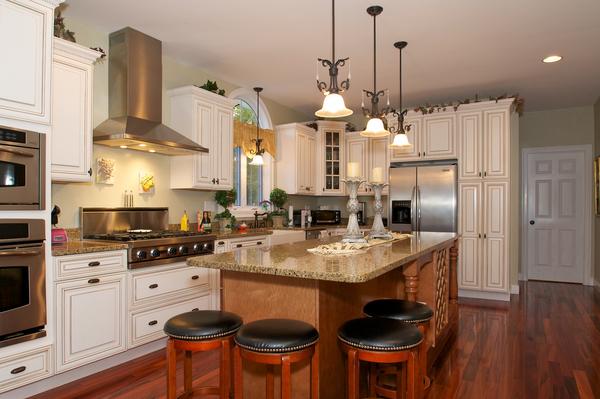 4 Devonshire Road Amesbury, MA 01913 - Photo 8 of 23 a kitchen with stainless steel appliances granite countertop a stove a refrigerator a sink a dining table and chairs with wooden floor