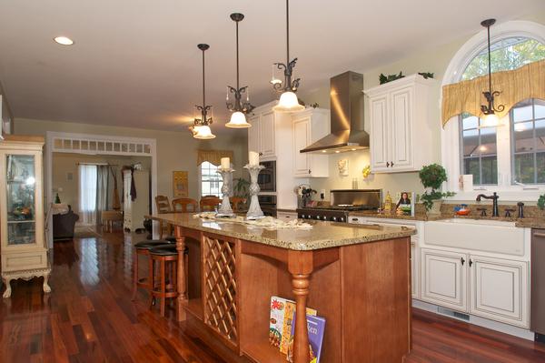 4 Devonshire Road Amesbury, MA 01913 - Photo 9 of 23 a kitchen with stainless steel appliances granite countertop a stove a sink dishwasher and a dining table with chandelier
