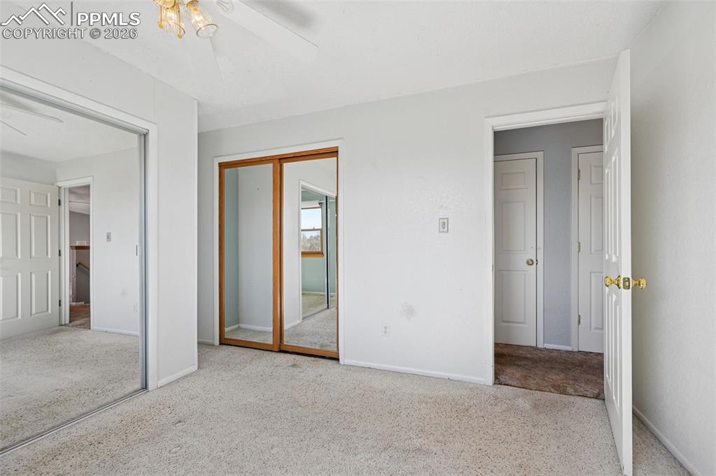 4963 Ridenour Drive Colorado Springs, CO 80916 - Photo 12 of 25 Unfurnished bedroom featuring a closet, light carpet, and a ceiling fan