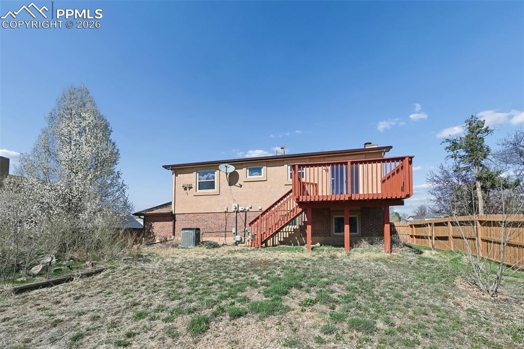 4963 Ridenour Drive Colorado Springs, CO 80916 - Photo 25 of 25 Rear view of property featuring a fenced backyard, a deck, and brick siding