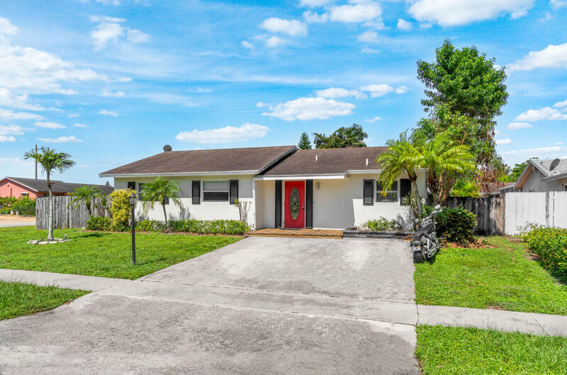 22775 Neptune Road Boca Raton, FL 33428 - Photo 1 of 18 a front view of house with yard and green space