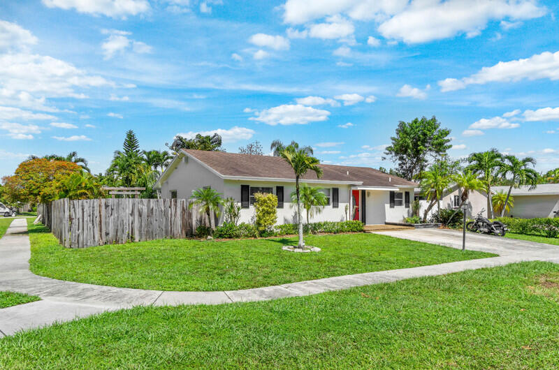 22775 Neptune Road Boca Raton, FL 33428 - Photo 2 of 18 a view of a big yard with a house in the background