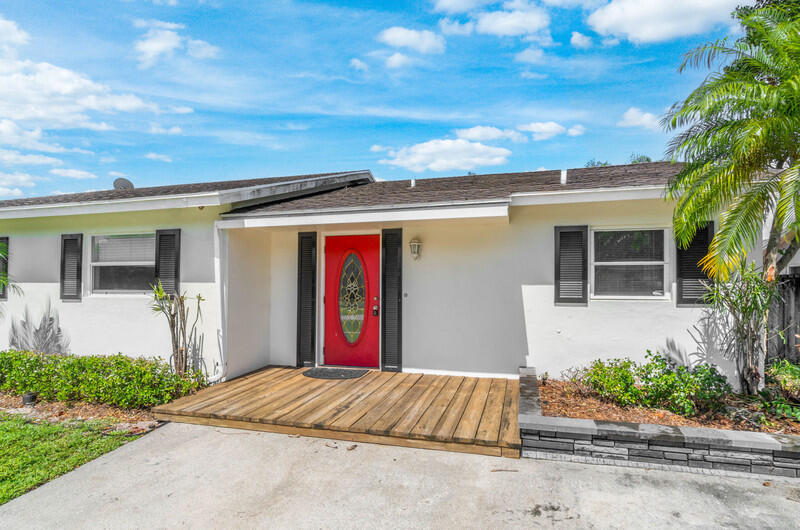 22775 Neptune Road Boca Raton, FL 33428 - Photo 3 of 18 front view of a house with a yard