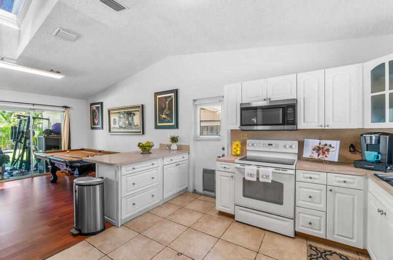 22775 Neptune Road Boca Raton, FL 33428 - Photo 4 of 18 a kitchen with white cabinets and sink