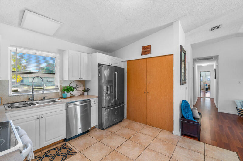 22775 Neptune Road Boca Raton, FL 33428 - Photo 5 of 18 a kitchen with stainless steel appliances a refrigerator and a sink