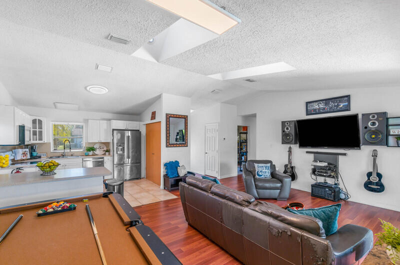 22775 Neptune Road Boca Raton, FL 33428 - Photo 7 of 18 a living room with furniture and a flat screen tv