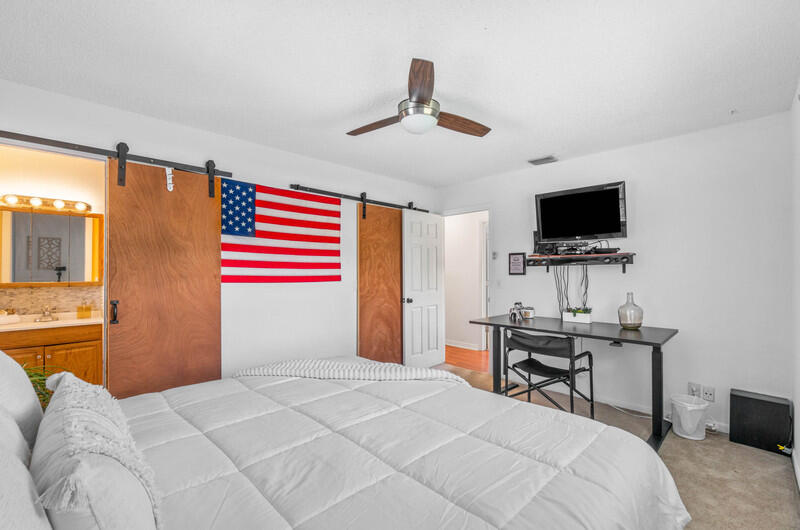 22775 Neptune Road Boca Raton, FL 33428 - Photo 8 of 18 a bedroom with a bed and a flat screen tv