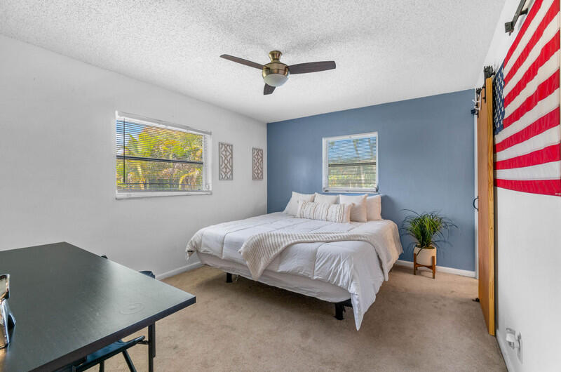 22775 Neptune Road Boca Raton, FL 33428 - Photo 9 of 18 a spacious bedroom with a bed and a desk