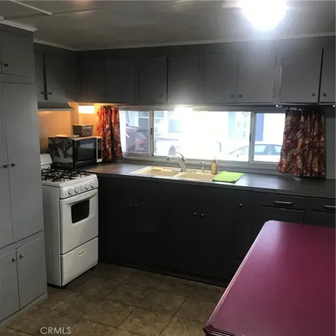 a kitchen with a sink a stove cabinets and a kitchen island