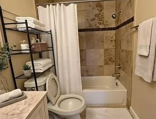 a bathroom with a granite countertop sink toilet and shower