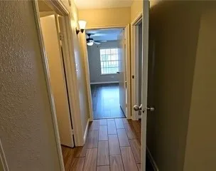 a view of a hallway with wooden floor and staircase