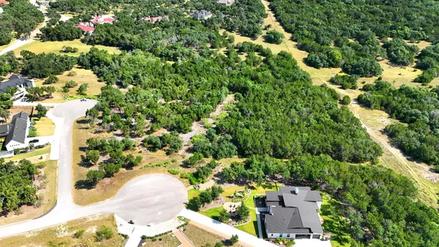 an aerial view of a house with a yard and large trees
