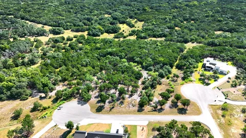 an aerial view of residential house with outdoor space and trees all around