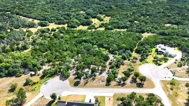 an aerial view of residential house with outdoor space and trees all around