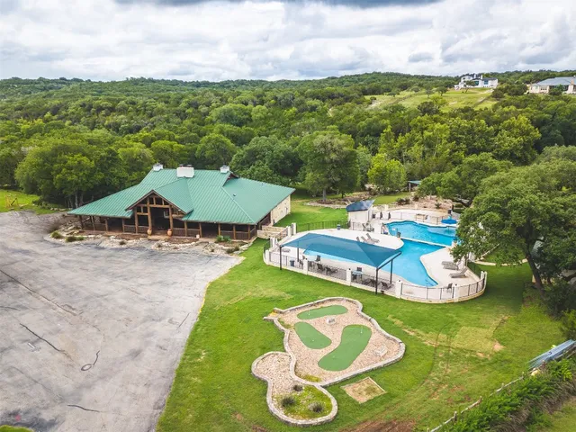 an aerial view of a house with a garden and lake view