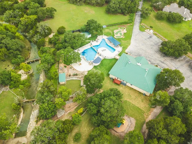 a front view of a house with a garden and trees