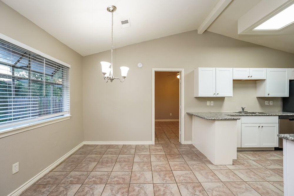 20117 Dawn Mist Drive Humble, TX 77346 - Photo 6 of 16 a kitchen with granite countertop a stove a sink and a refrigerator