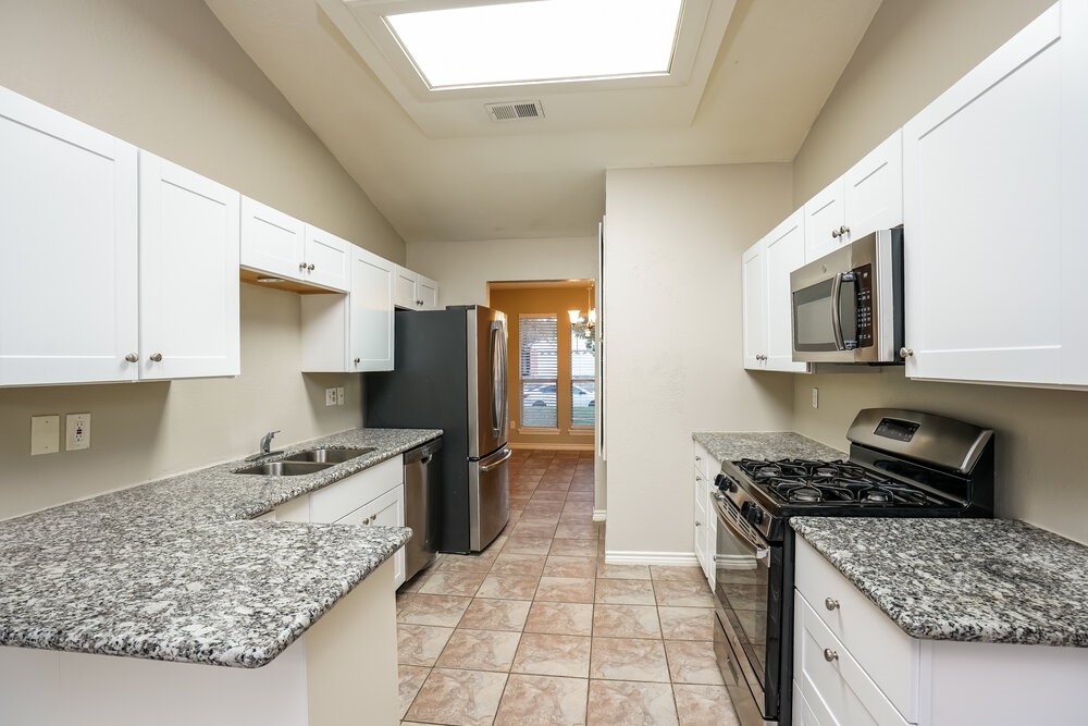 20117 Dawn Mist Drive Humble, TX 77346 - Photo 9 of 16 a kitchen with stainless steel appliances granite countertop a stove top oven a sink dishwasher and a refrigerator