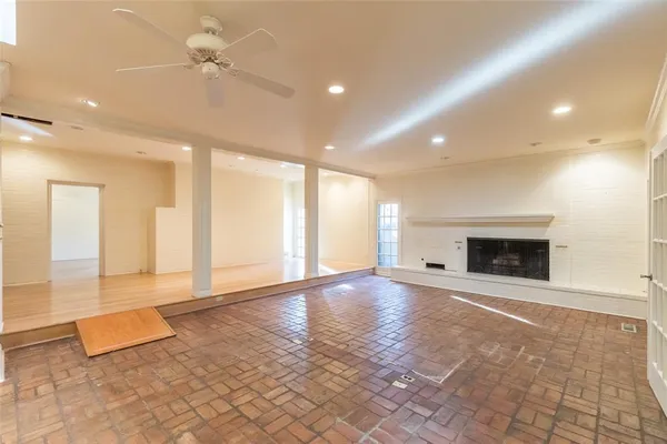 a view of an empty room with a fireplace and a window