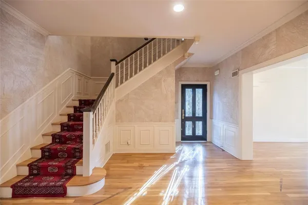 a view of an entryway with wooden floor and stairs