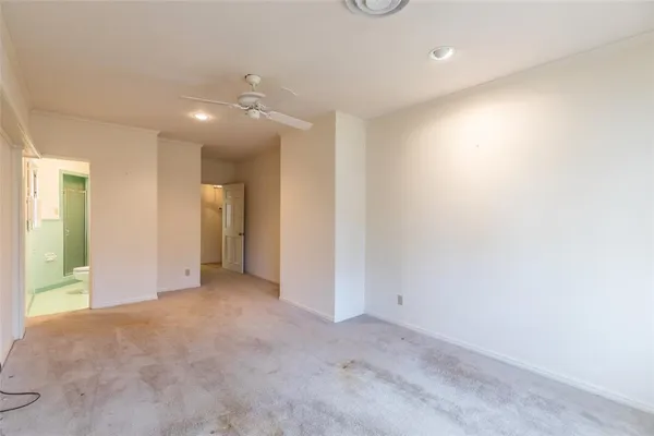 an empty room with an entryway and kitchen view
