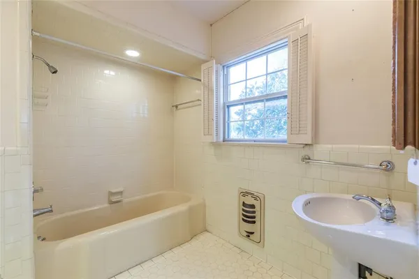 a bathroom with a sink a bathtub and a window