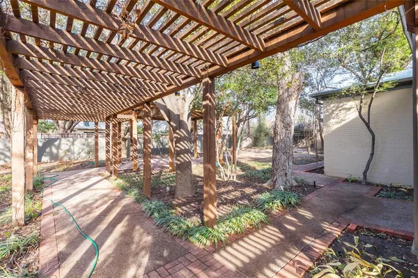 a backyard of a house with large trees and plants