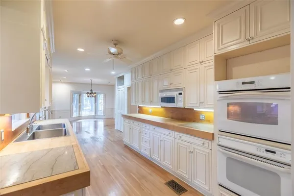 a kitchen with granite countertop white cabinets and white appliances