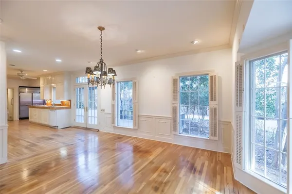 a view of a big room with wooden floor and windows