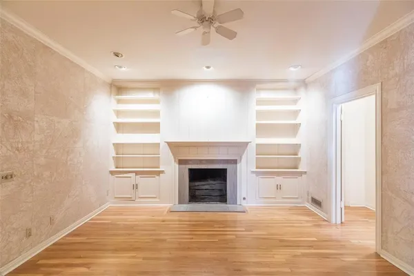 a view of an empty room with a window and fireplace